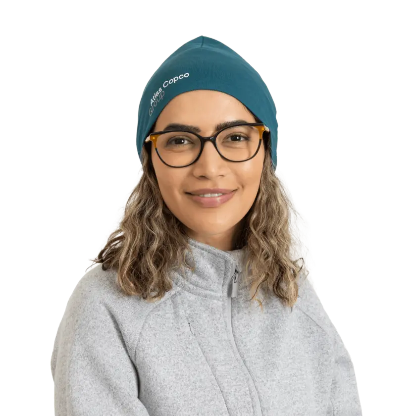 woman wearing teal beanie with atlas copco group logo