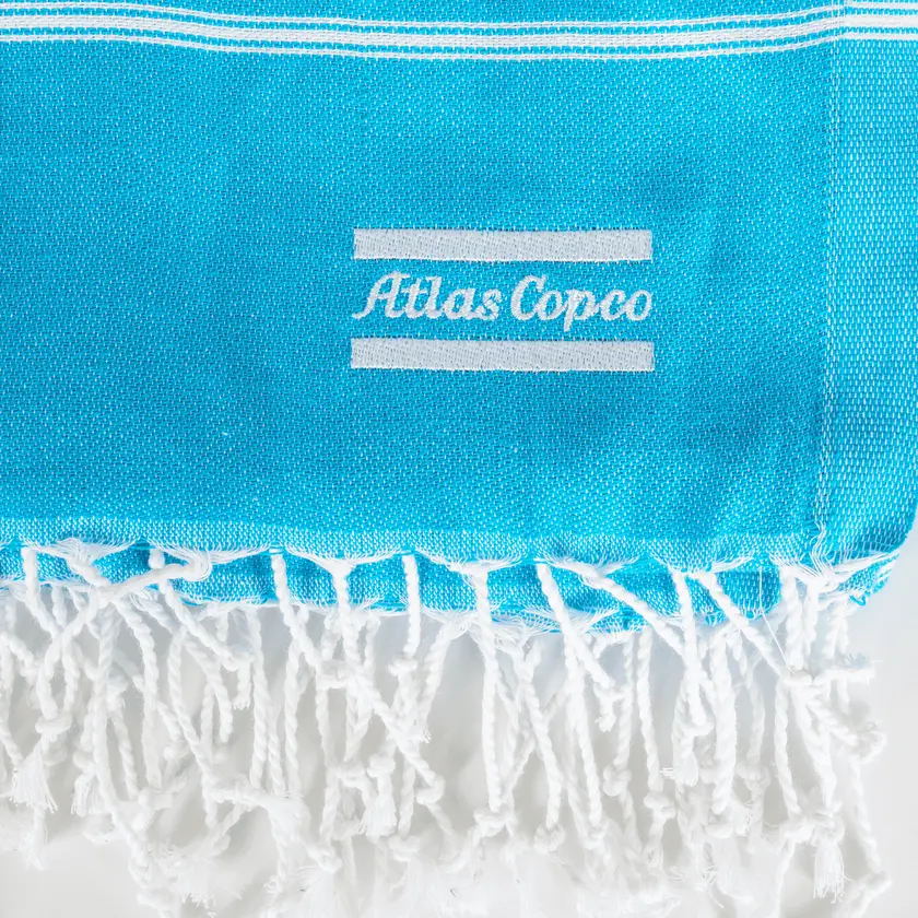 Blue towel with white atlas copco logo