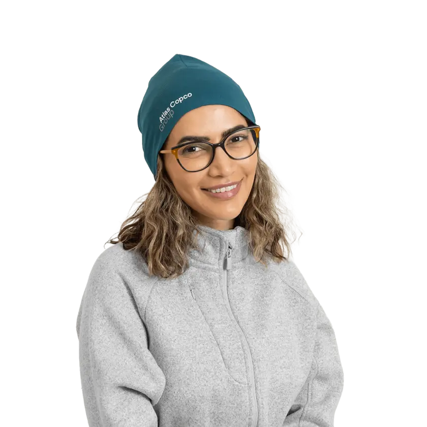 woman wearing teal beanie with atlas copco group logo