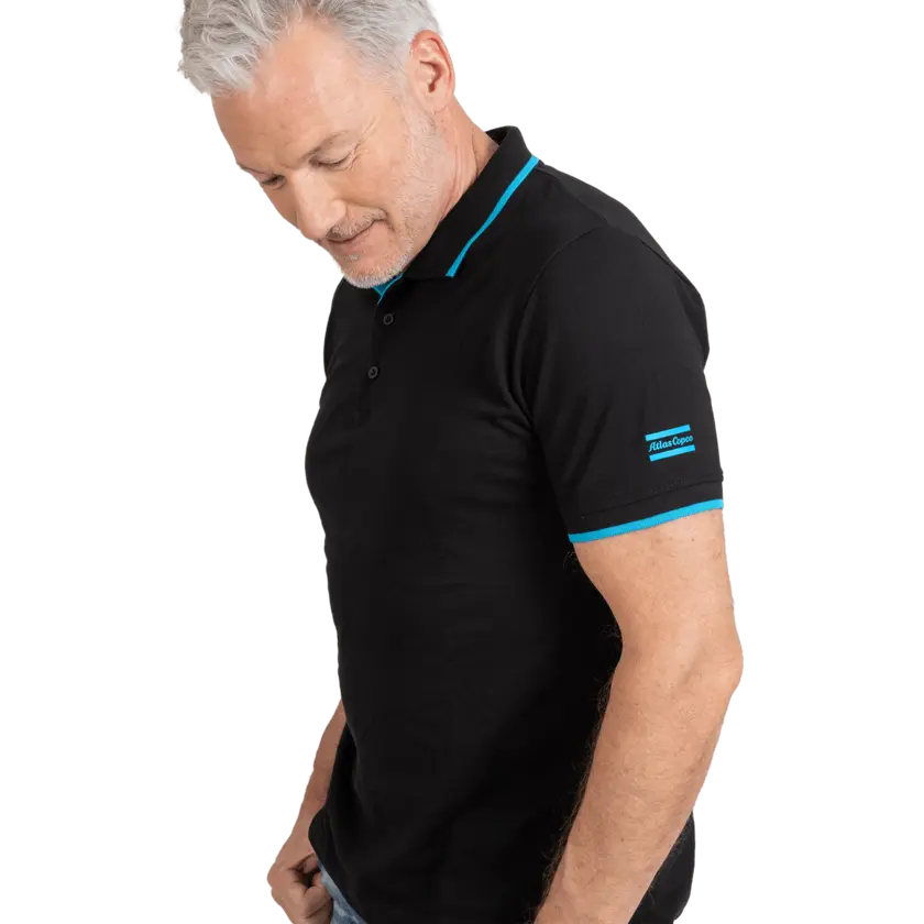 Man wearing black polo shirt with blue details and atlas copco logo on sleeve